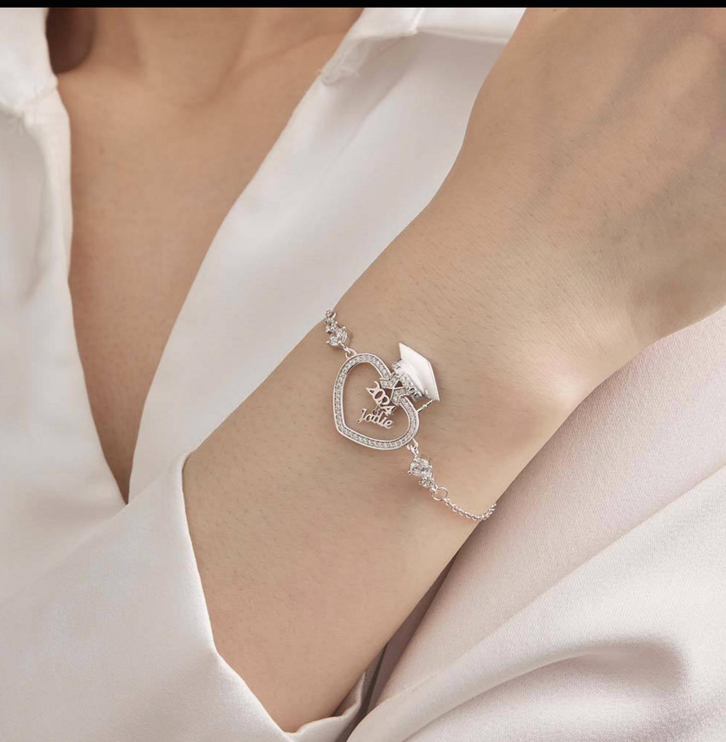 Silver bracelet with heart design on a person's wrist against a white background
