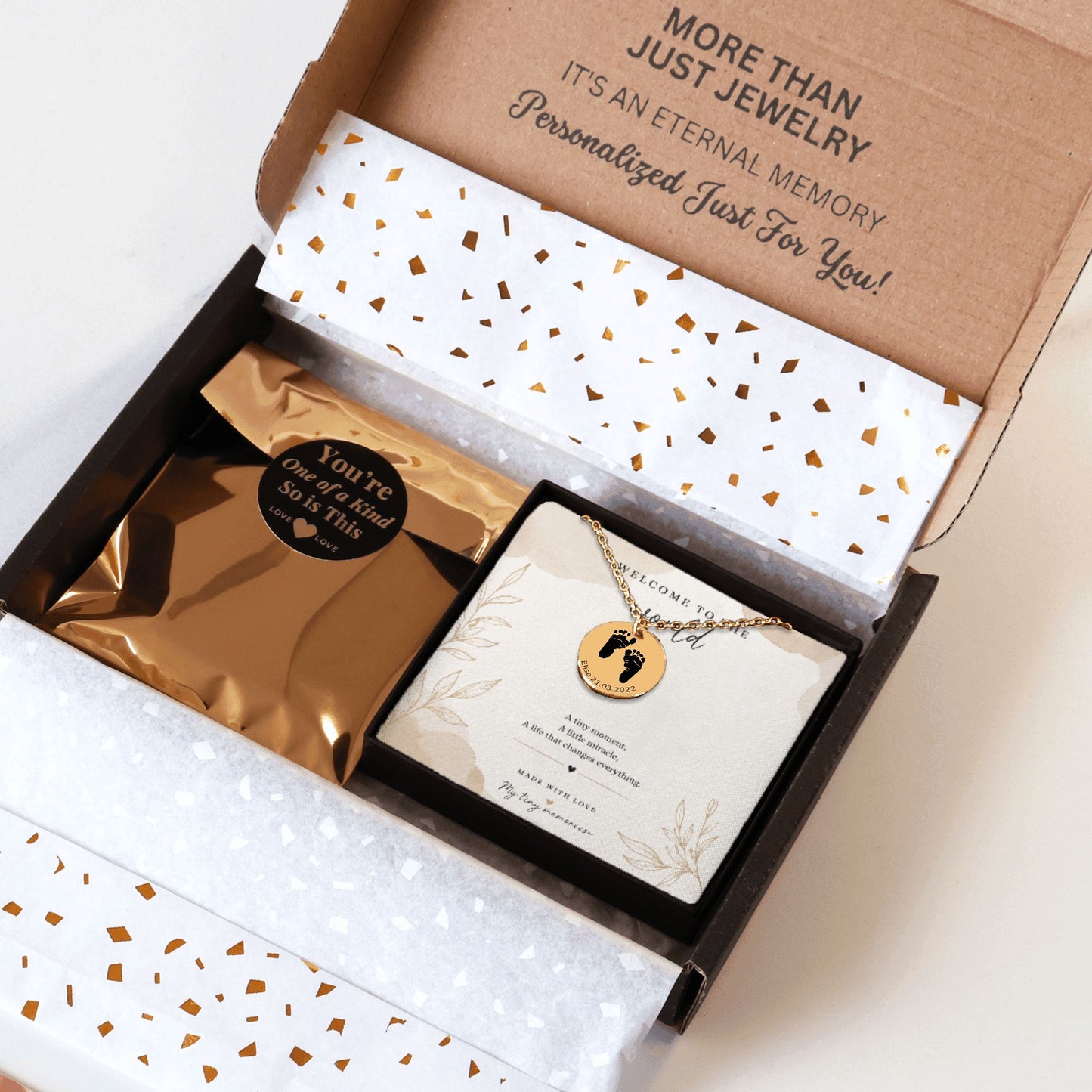 Jewelry box with a necklace and card inside, featuring gold and white design elements.