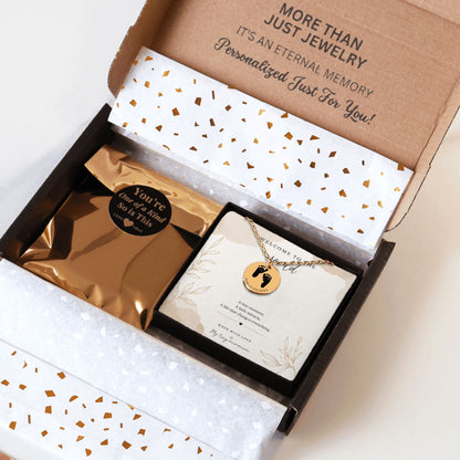 Jewelry box with a necklace and card inside, featuring gold and white design elements.