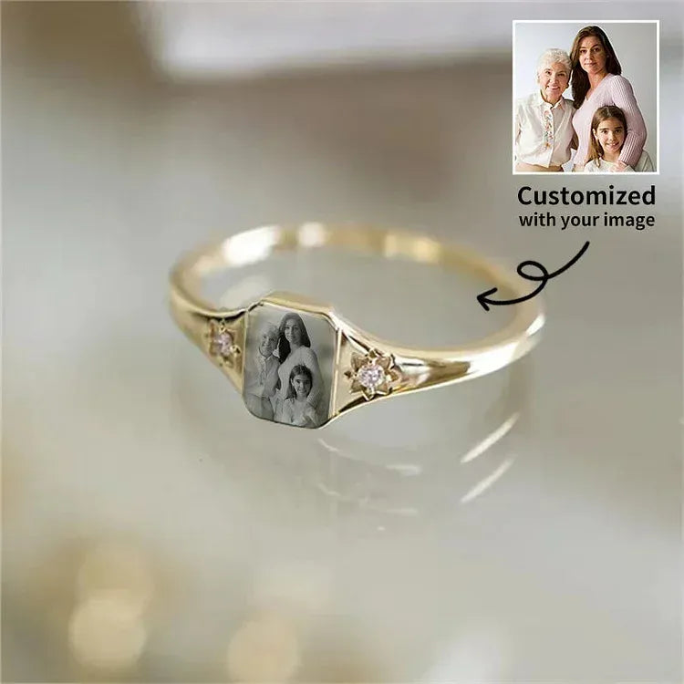 Gold ring with a family photo engraving on a light background