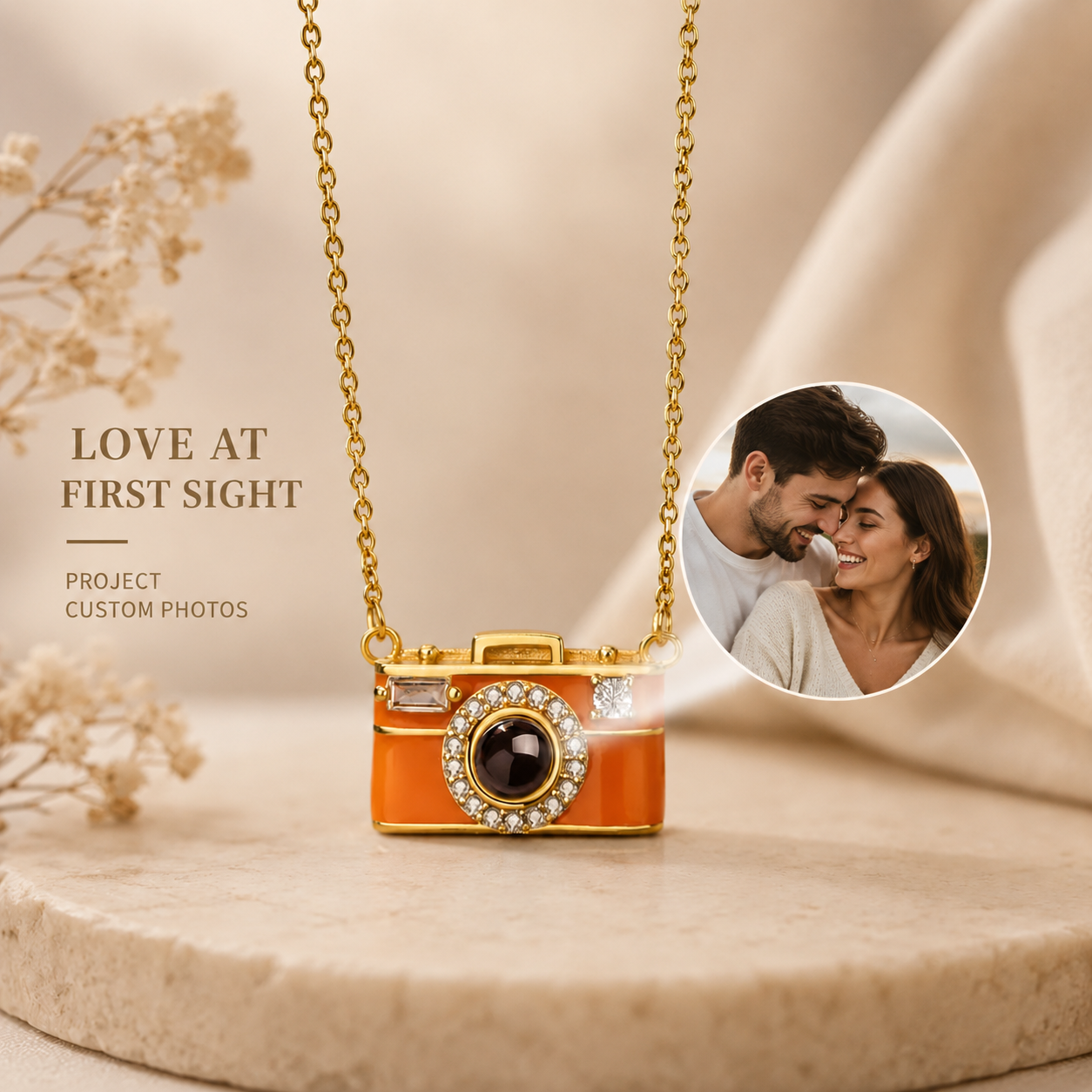 Camera-shaped projection pendant necklace on a beige surface with a couple in a circular inset.