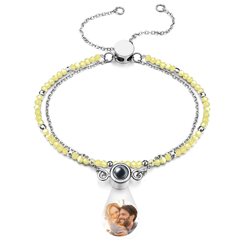 Bracelet with yellow beads and a teardrop-shaped charm featuring a photo of a couple.