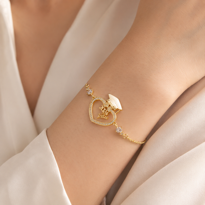 Gold bracelet with heart design on a wrist against a neutral background