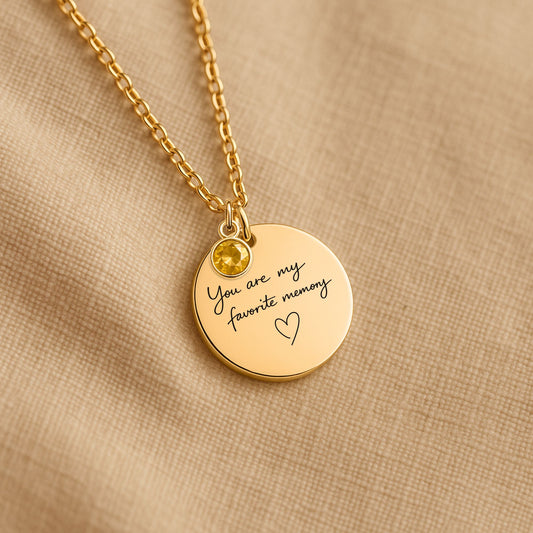 Personalized birthstone necklace with You Are My Favorite Memory engraving photographed on neutral fabric background