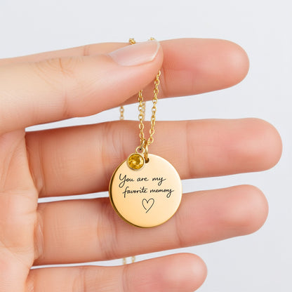 Hand holding personalized engraved birthstone necklace to show pendant size and detail