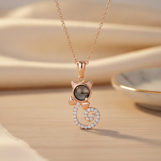 Rose gold cat-shaped pendant necklace on a beige background