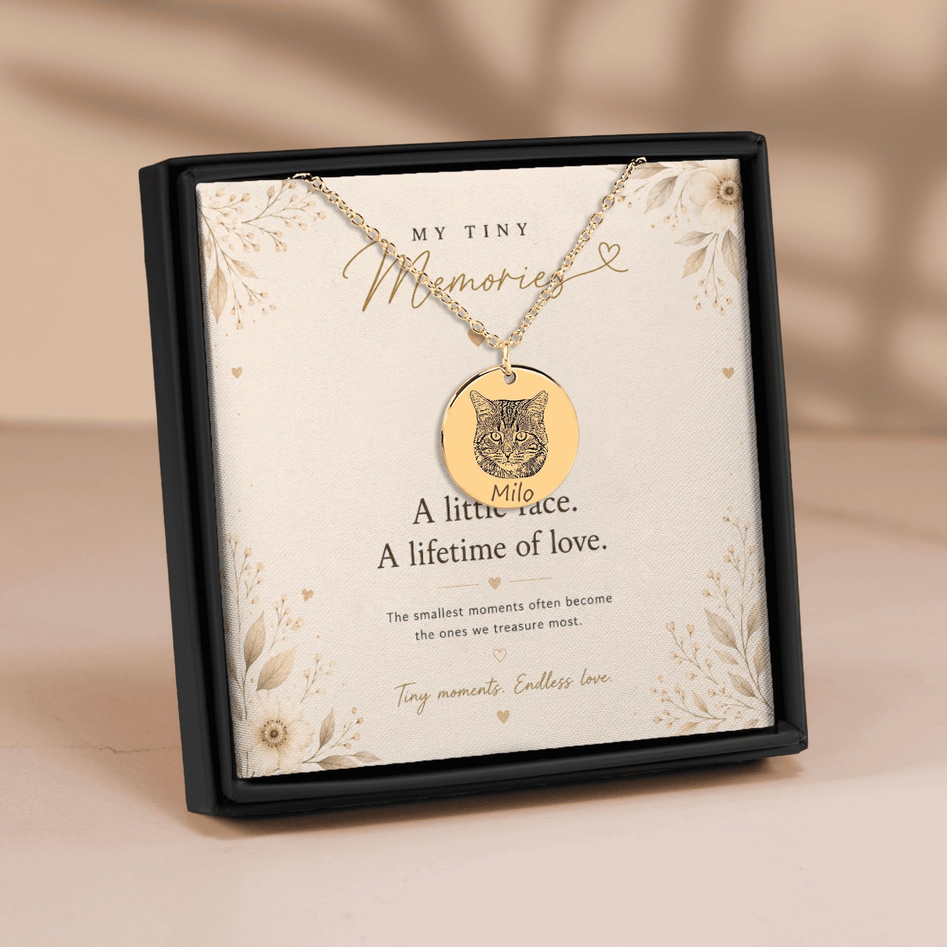Personalized gold cat portrait necklace displayed in a luxury gift box with a sentimental message card and soft floral details.
