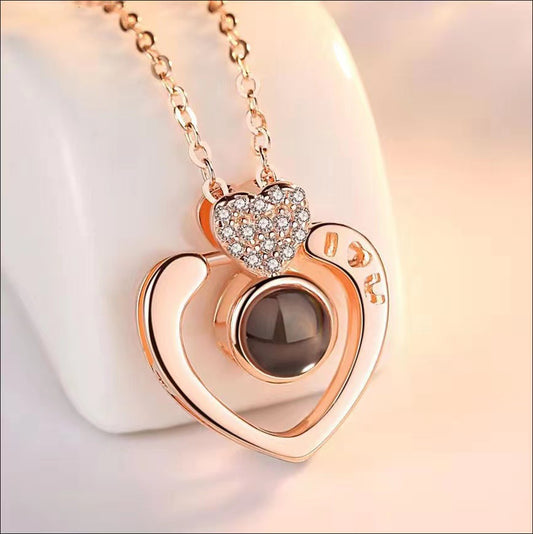 Heart-shaped necklace with rose gold plating and gemstone on a light background